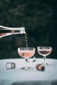 Pink Sparking wine or champagne is being poured into a champagne coupe.
