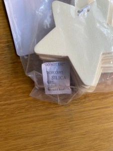This shows the small pack of silica gel inside the packaging at the bottom.