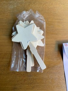 The contents of the packet - showing 4 ready assembled wooden star clappers.