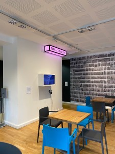 Part of the foyer seating area right next to an exhibition wall.