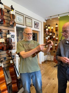 David Johnson checking over a violin on the main shop floor.