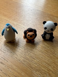 Three little "Practice Buddies" that I bought for my children to use in their musical instrument practice. These are cute little erasers which are shaped like small animals. Here we have a little blue and white penguin, a tiny orange lion with a brown mane and face, and a little black and white panda.
