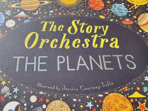 The cover of the book The Story Orchestra: The Planets. It has a black cover, fitting for a book about space, and illustrations of planets, stars, moons, alien ships and even what looks like a snow topped mountain on.